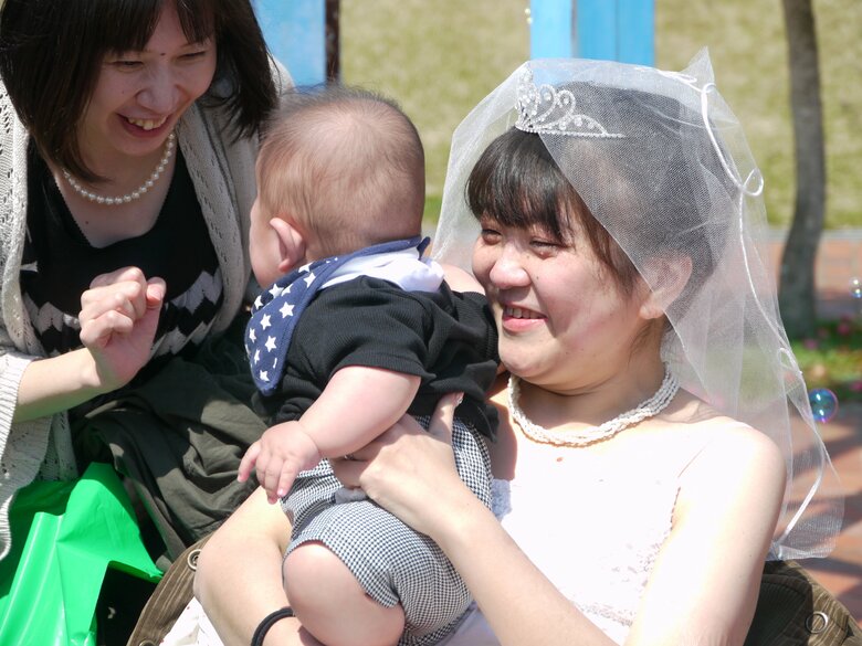 生まれて間もない息子を友達に披露して笑顔の睦さん