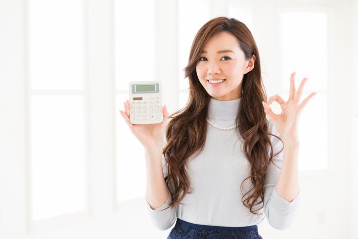 Woman of the smile having an electronic calculator