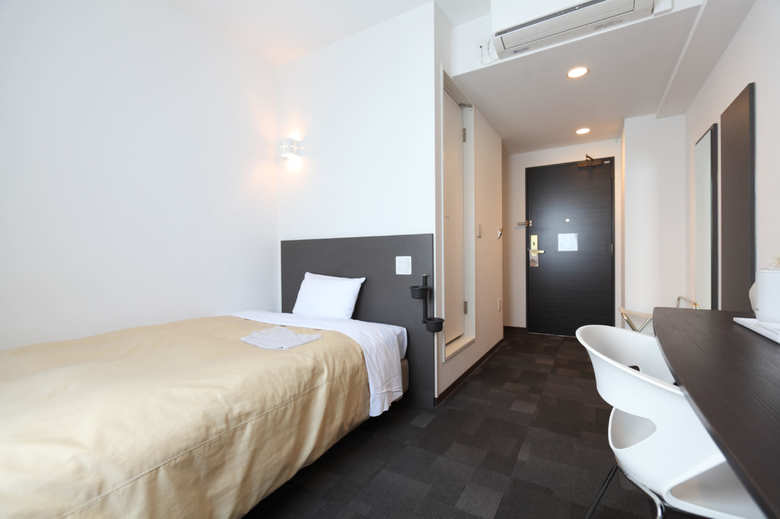 サテライトオフィスとして利用されることもある客室（セミダブル）。ワーキングスペースとしての快適さを考え、加湿器やデスクライトの貸し出しなどを行っている。