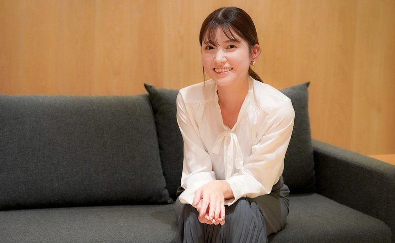 ゆったりとソファに腰かけチャーミングな表情の新保さん