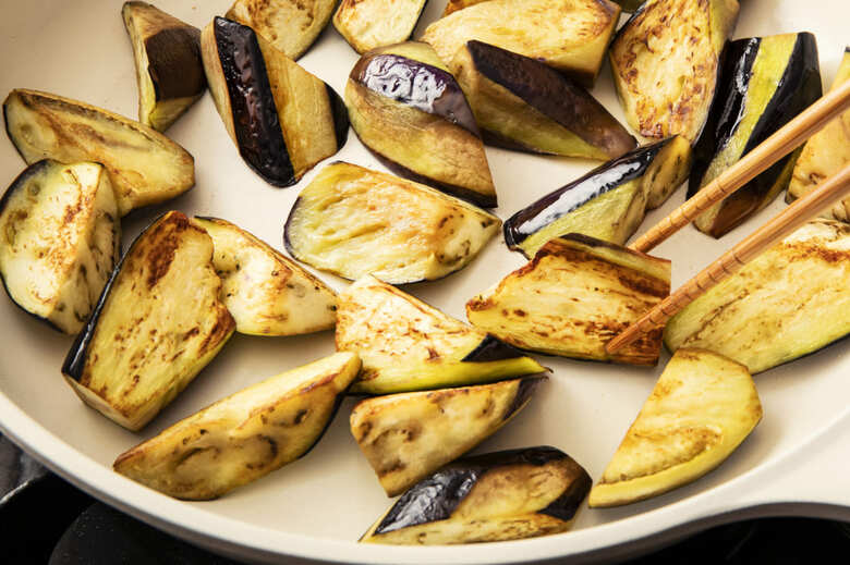 フライパンにごま油を中火で熱し、なすを入れる。あまり触らないようにして焼き色がついてきたら返しながら3〜４分ほど焼く。なすがしんなりしてきて全体に焼き色がついたら取り出す。