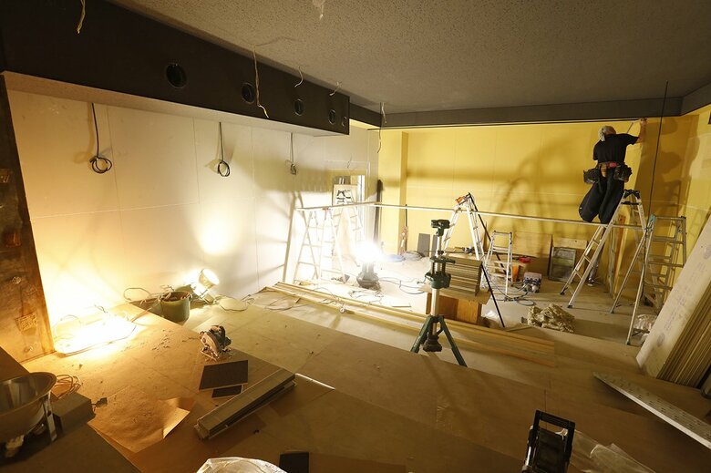 客席後方から見たスクリーン設置予定場所。左上の細長い黒い装置が換気設備