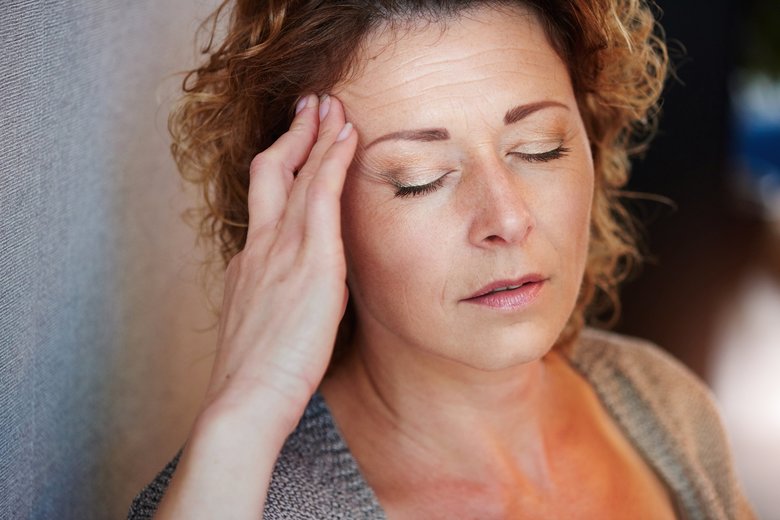 Older woman with hand to head in pain