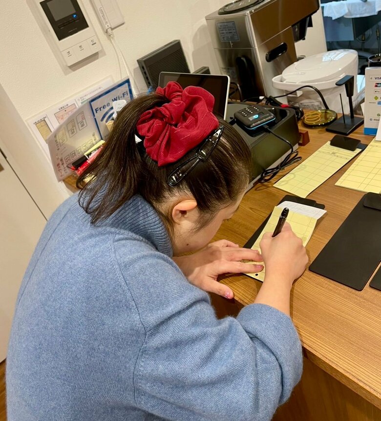 2025年、喫茶店でオーダーを書く翔子さん