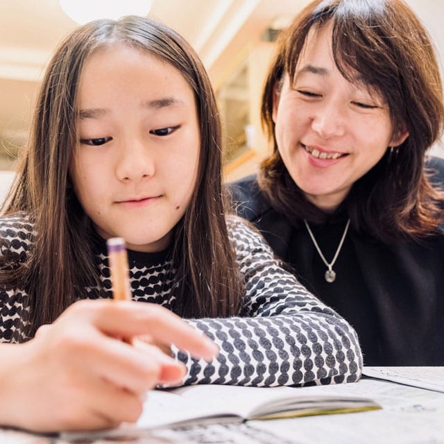 娘の勉強を見る石黒香さん（右）