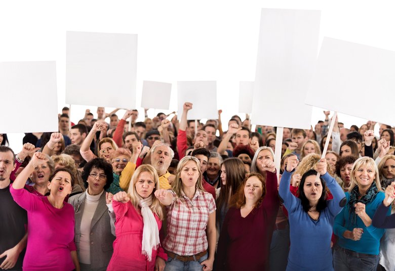 Group of displeased people holding banners and looking at camera