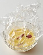 耐熱性のミニカップなどにラップを敷いてミニトマトとチーズを入れ、Cを流し入れて、ふんわりとラップをする。