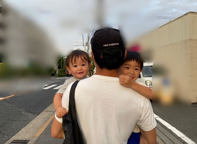 長男と次男を抱えて歩く豊崎さんの夫