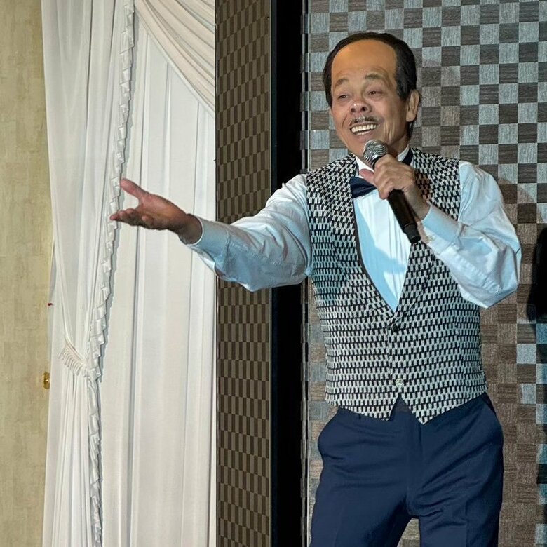 谷村新司さんのものまねを披露する清水アキラさん