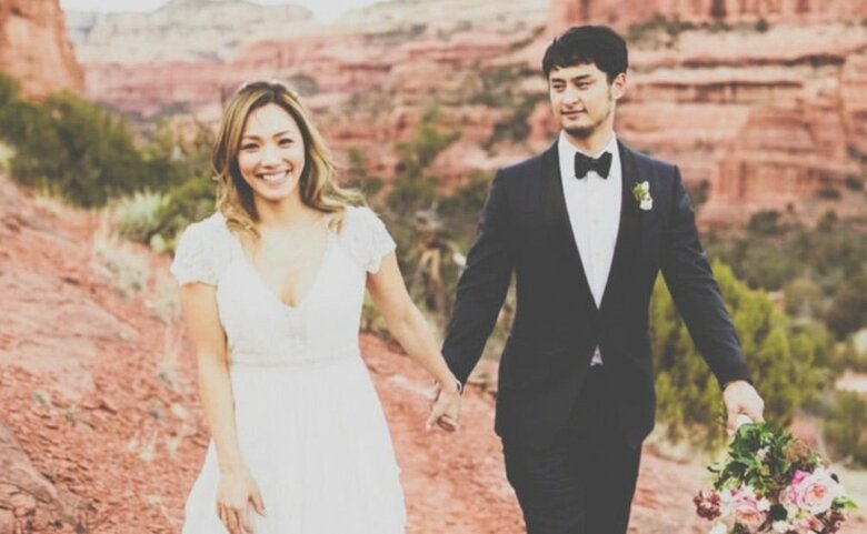 ダルビッシュ聖子さんのウェディングフォト。純白のドレスに身を包んだご夫婦の手繋ぎショットがおしゃれ！