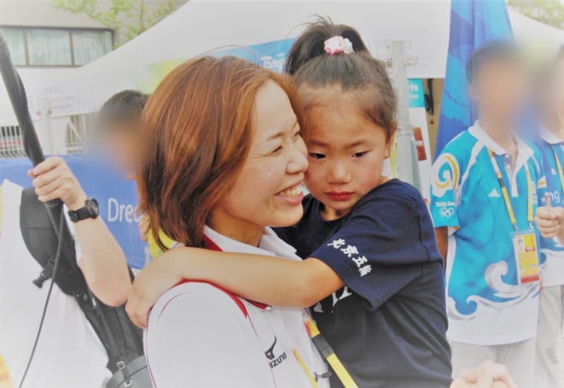 北京五輪で長女の芽生さんを抱くクレー射撃の中山由起枝選手(写真提供・中山由起枝選手)