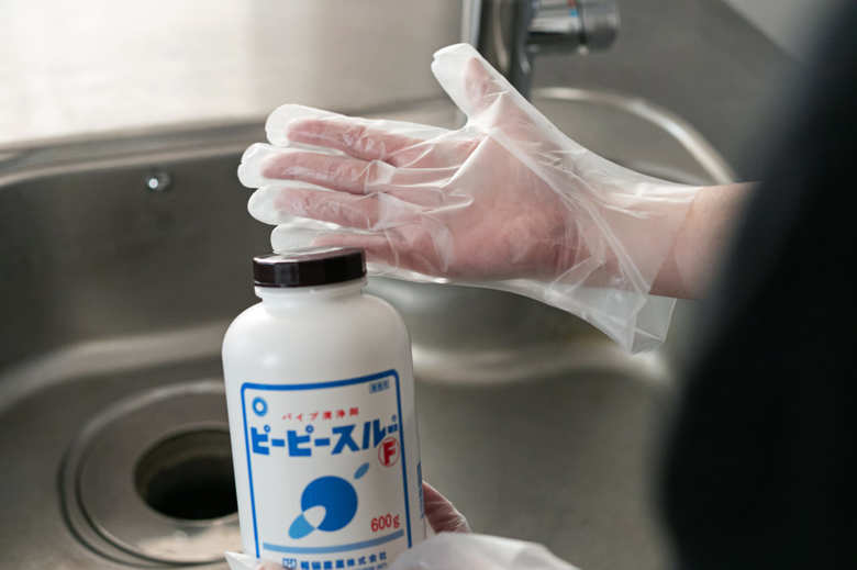 ビニール手袋をつけてピーピースルーFを持っているところ