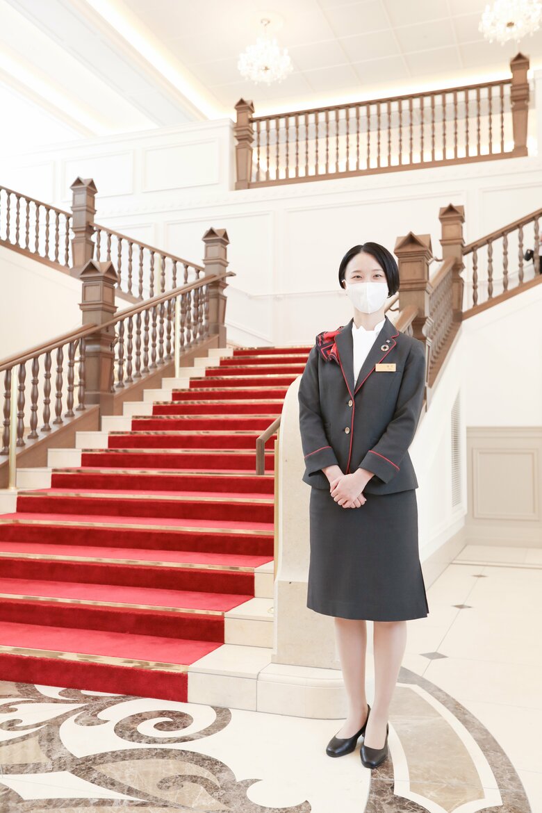 メインロビーの階段に立つ憧花ゆりのさん。制服はもともとパンツスタイルだったが、憧花さんの希望でスカートに