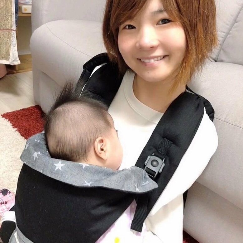 娘を抱っこ紐で抱えて