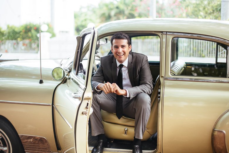 Handsome man sitting in an old classic car