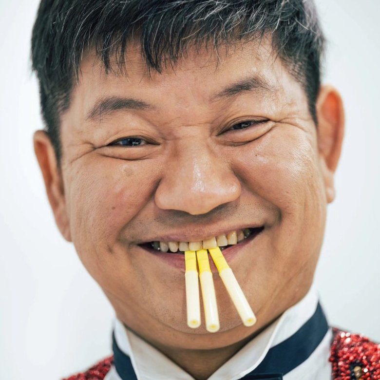 タバコ型の禁煙グッズを口にする大城さん。断酒と同時期に禁煙も決意