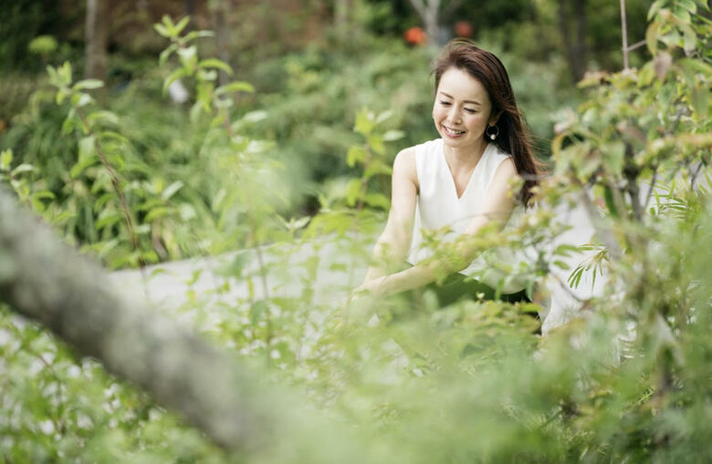 ハーブ園でリラックスした笑顔を見せる宮崎さん