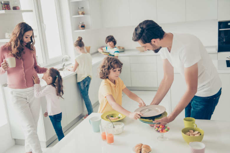 Big nice beautiful cheerful foster joyful caucasian family, six people, doing housework, dishes, cleaning, mom drinking cacao, son helping daddy, white light interior dining room, preteen